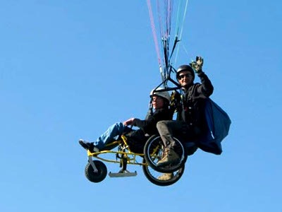 Parapente en bi-place avec une personne en fauteuil roulant