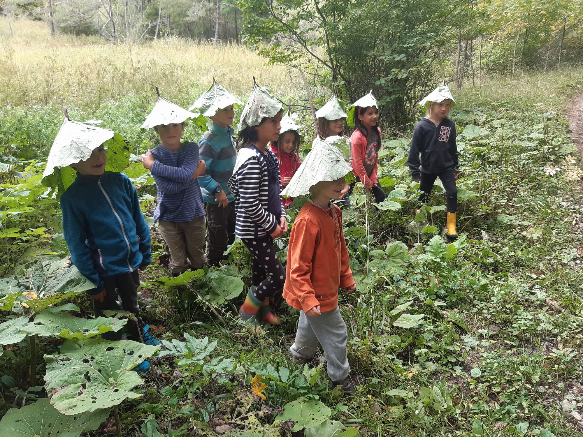 enfants avec des chapeaux en feuille sur la tête